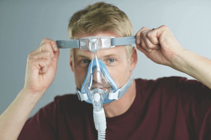 side sleeper putting on a cpap mask